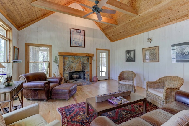 living room featuring hardwood / wood-style flooring, beam ceiling, ceiling fan, and a fireplace