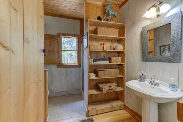 bathroom with wooden ceiling, wood walls, and hardwood / wood-style flooring