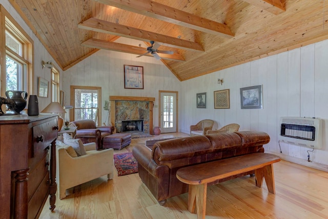 living room with a stone fireplace, wooden ceiling, and light wood-type flooring