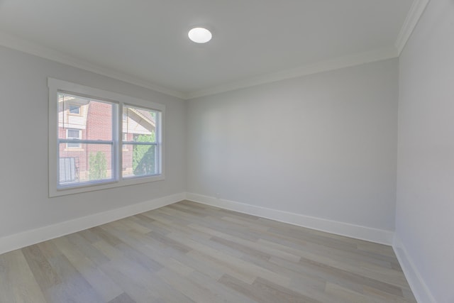 empty room with crown molding and light wood-type flooring