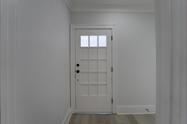 doorway to outside with ornamental molding and light hardwood / wood-style floors