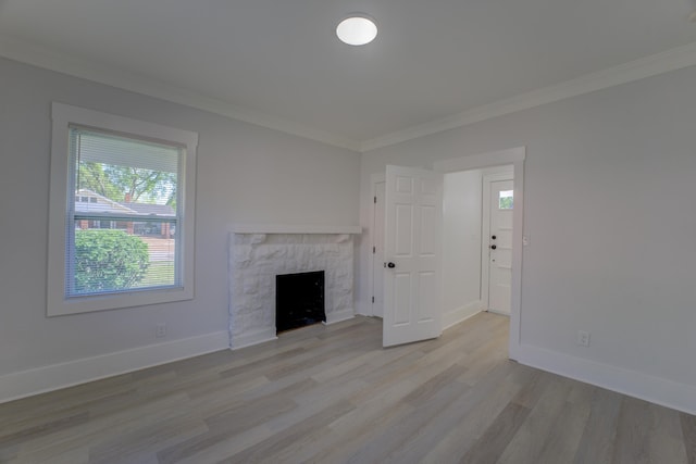 unfurnished living room featuring light hardwood / wood-style flooring, crown molding, and a fireplace