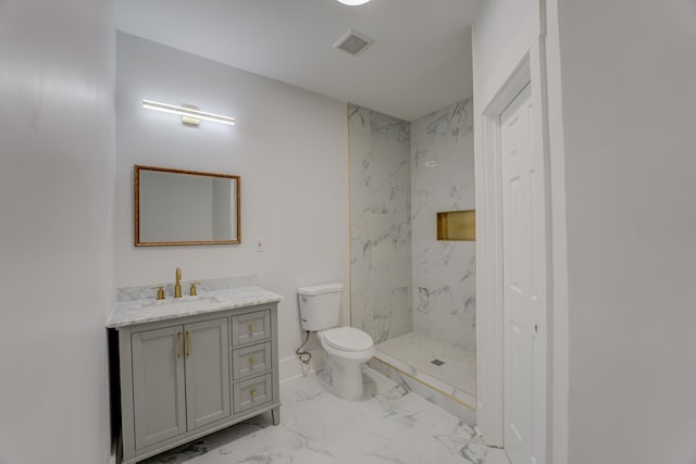 bathroom with vanity, tile floors, toilet, and a tile shower