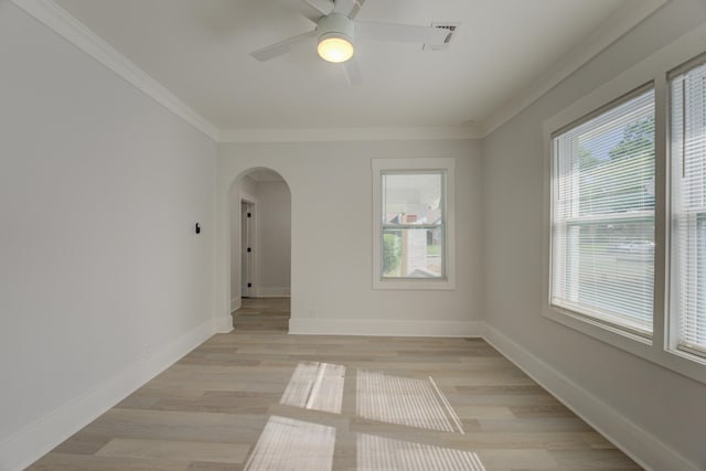 empty room featuring ceiling fan, crown molding, and light wood-type flooring