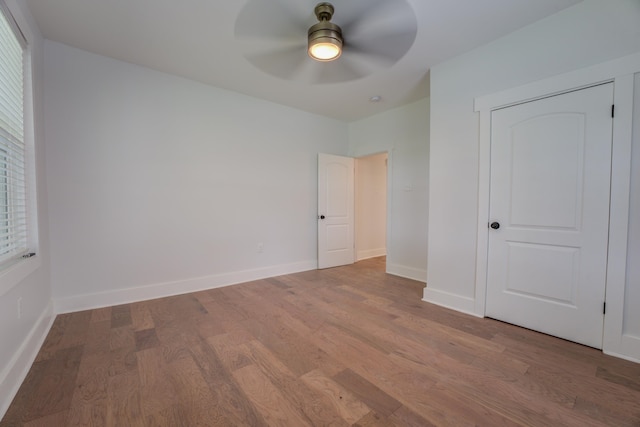 unfurnished bedroom with a closet, wood-type flooring, and ceiling fan