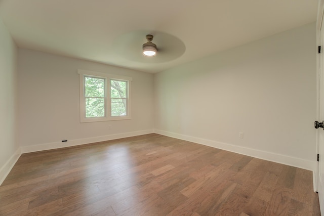 empty room featuring dark wood-type flooring and ceiling fan