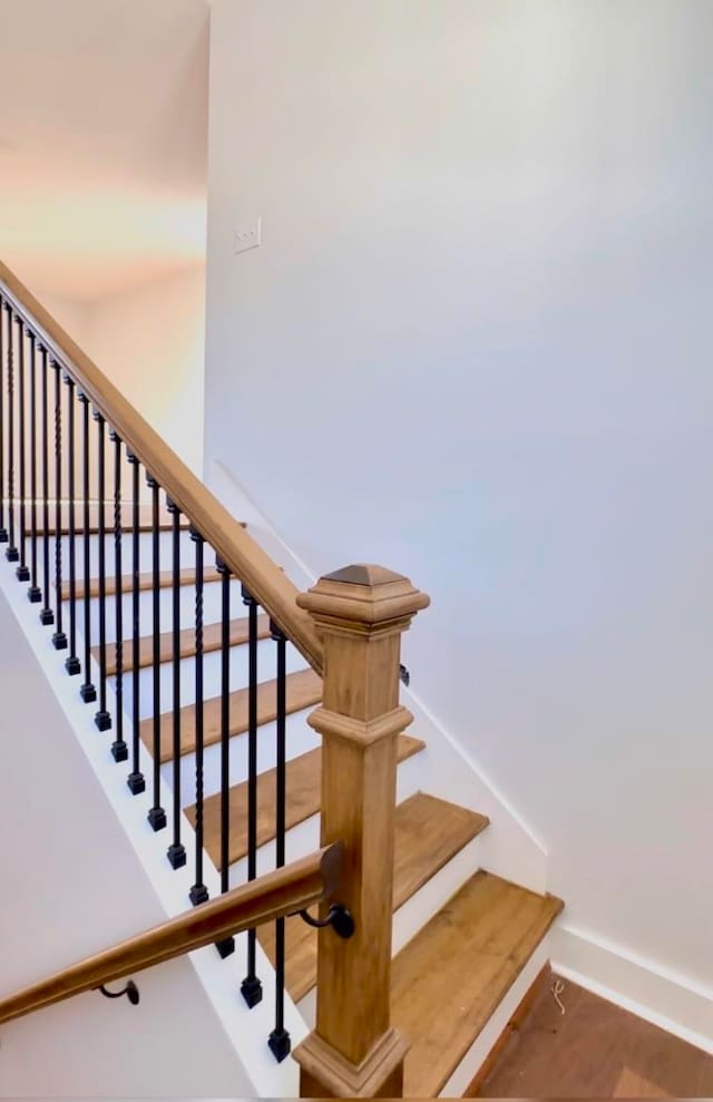 staircase with hardwood / wood-style floors