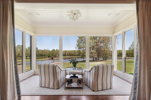 sunroom / solarium with a notable chandelier, a healthy amount of sunlight, and a water view