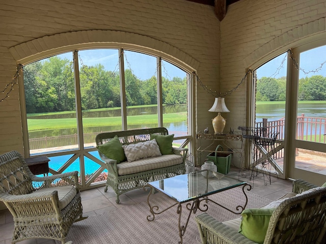 sunroom featuring a water view