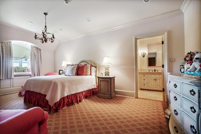 carpeted bedroom featuring ornamental molding, a notable chandelier, and ensuite bath