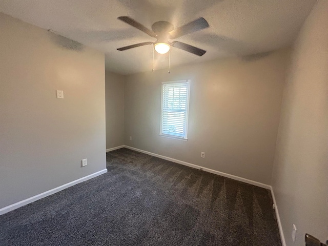 spare room with ceiling fan, a textured ceiling, and dark colored carpet