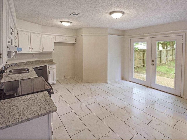 kitchen with baseboards, french doors, white cabinets, marble finish floor, and a sink