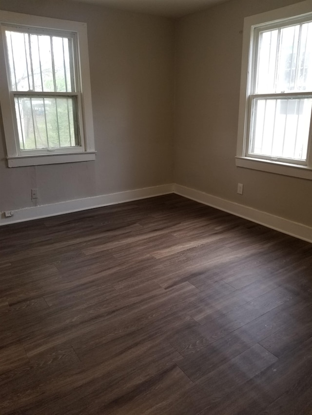 spare room featuring plenty of natural light and dark hardwood / wood-style floors