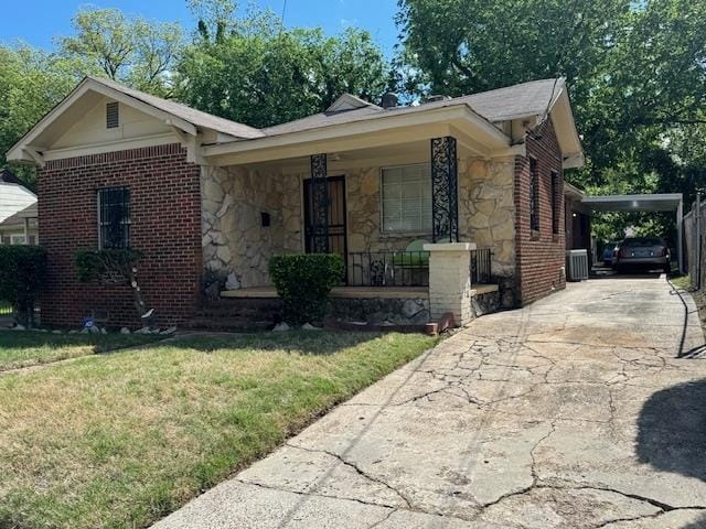 view of front of home with a front yard, a carport, and a porch