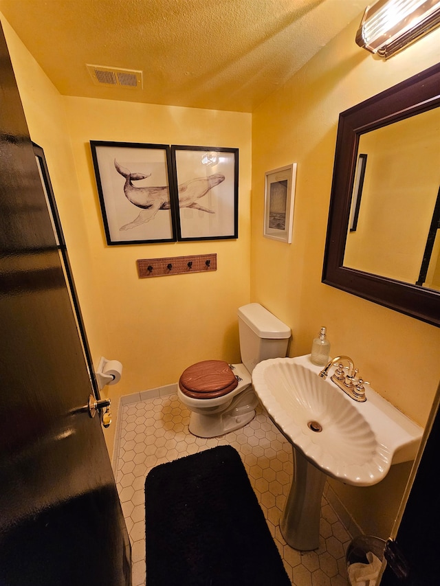 bathroom with a textured ceiling and toilet