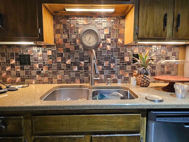 kitchen with dishwasher, sink, decorative backsplash, and light stone counters