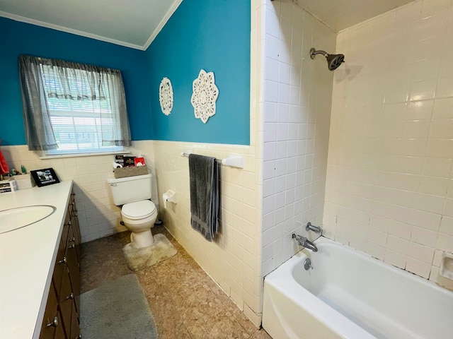 full bathroom featuring toilet, tiled shower / bath, vanity, ornamental molding, and tile walls