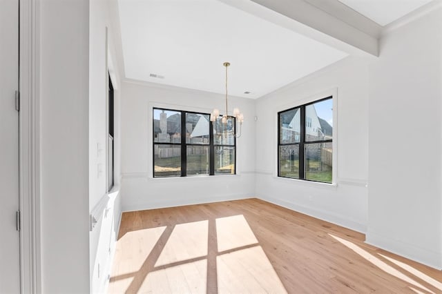 spare room with wood-type flooring and a notable chandelier