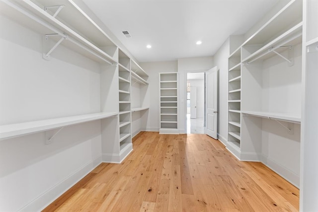 walk in closet with light hardwood / wood-style floors