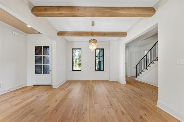 entryway featuring beamed ceiling, an inviting chandelier, and light wood-type flooring