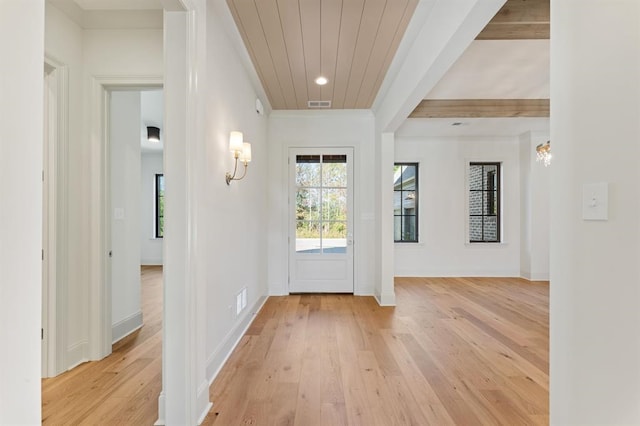 doorway with beamed ceiling and light hardwood / wood-style flooring