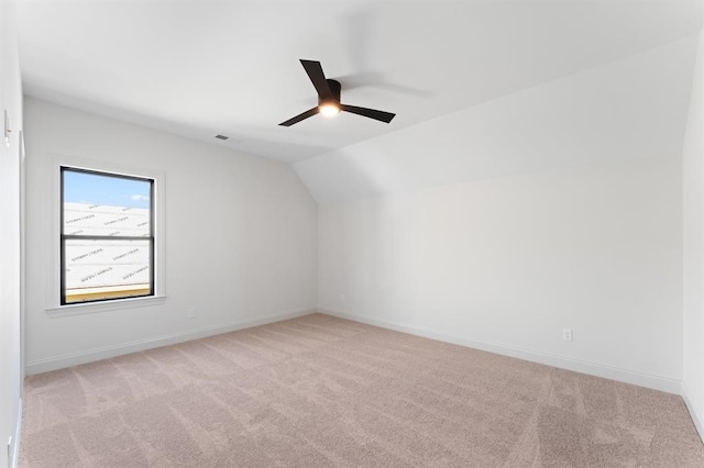 empty room with lofted ceiling, ceiling fan, and carpet flooring