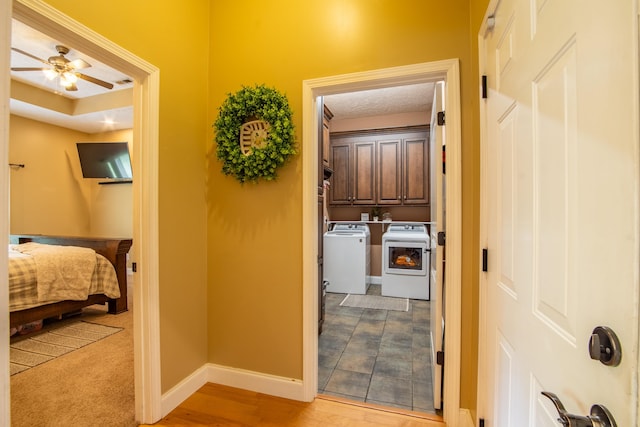 hallway featuring independent washer and dryer and light tile flooring