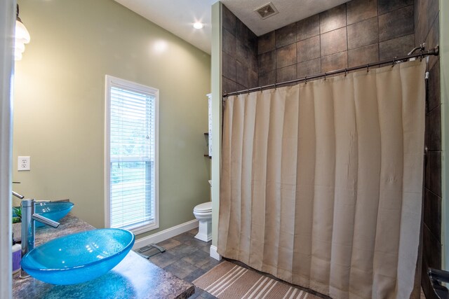 bathroom featuring sink, toilet, and tile floors