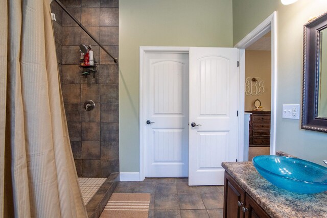 bathroom with walk in shower, vanity, and tile flooring