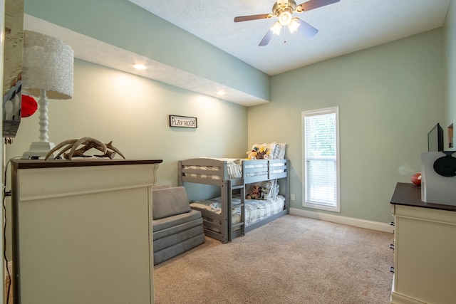 carpeted bedroom featuring ceiling fan, a textured ceiling, and multiple windows