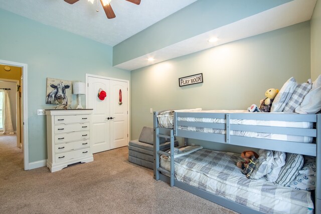 bedroom with light colored carpet, ceiling fan, and a closet