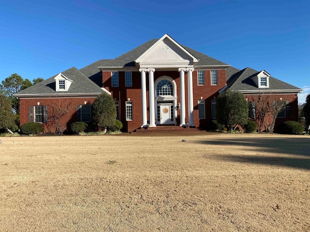 greek revival inspired property featuring a front yard