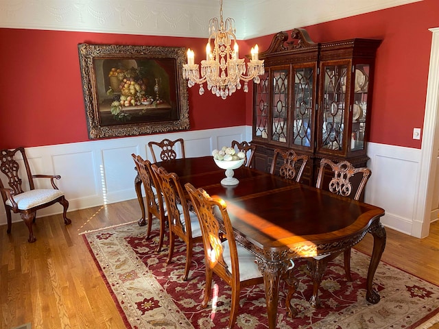 dining area featuring an inviting chandelier and hardwood / wood-style flooring