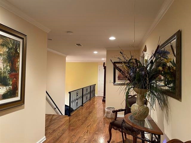 corridor featuring crown molding and hardwood / wood-style flooring