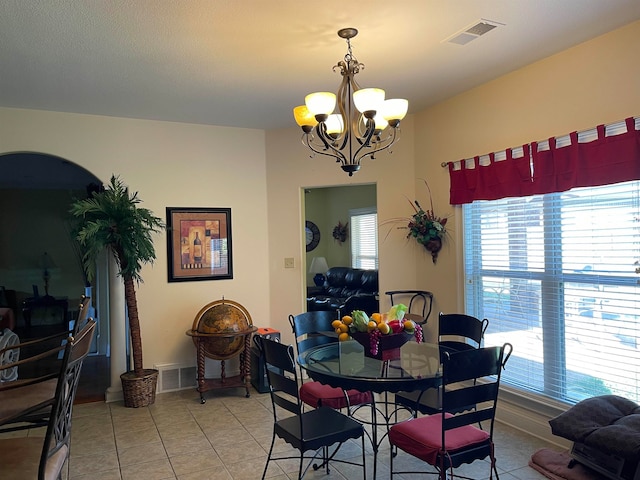 tiled dining area with an inviting chandelier