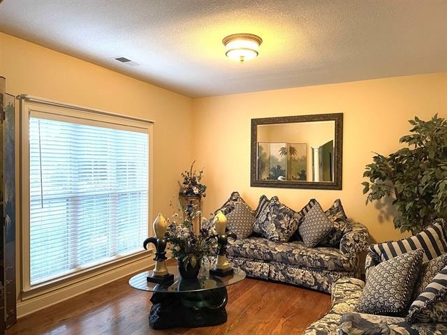 living room featuring a textured ceiling and hardwood / wood-style floors