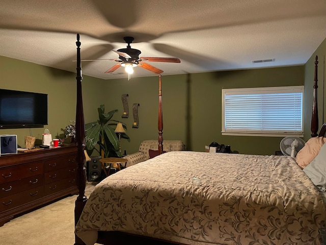 carpeted bedroom featuring a textured ceiling and ceiling fan