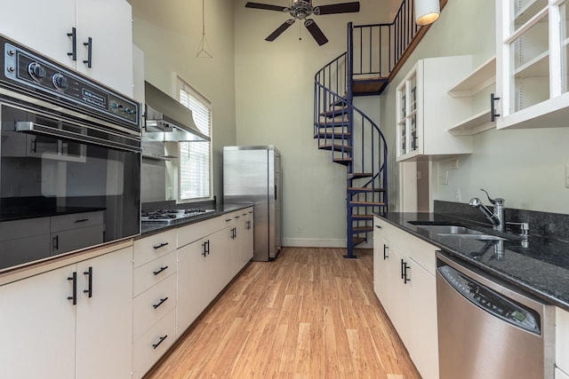 kitchen featuring white cabinets, light wood-type flooring, appliances with stainless steel finishes, sink, and ceiling fan