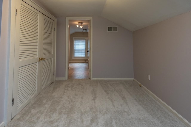 interior space featuring light colored carpet and vaulted ceiling