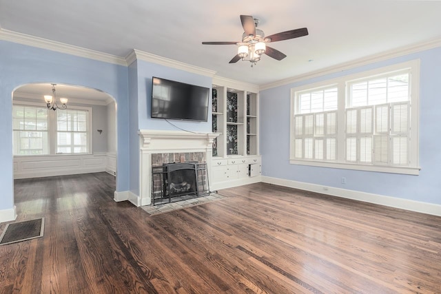 unfurnished living room featuring ceiling fan with notable chandelier, dark hardwood / wood-style flooring, and crown molding