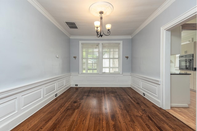 unfurnished room with ornamental molding, an inviting chandelier, and hardwood / wood-style floors