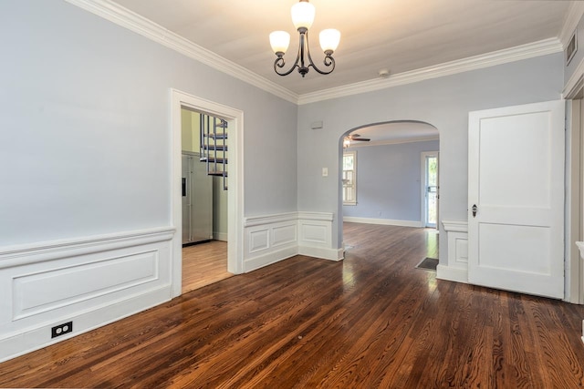 spare room featuring a chandelier, crown molding, and dark hardwood / wood-style flooring