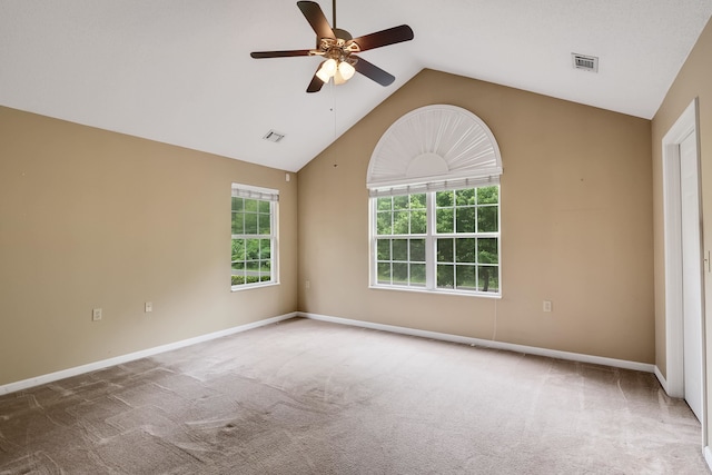 carpeted empty room featuring a healthy amount of sunlight, ceiling fan, and vaulted ceiling