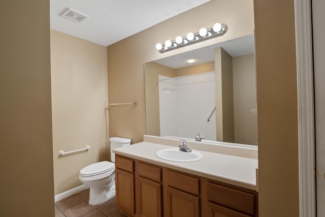 bathroom featuring tile floors, oversized vanity, toilet, and a textured ceiling