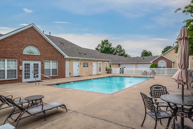 view of swimming pool featuring french doors and a patio