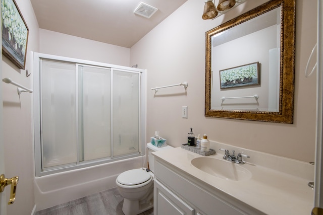 full bathroom with toilet, bath / shower combo with glass door, vanity, and hardwood / wood-style floors