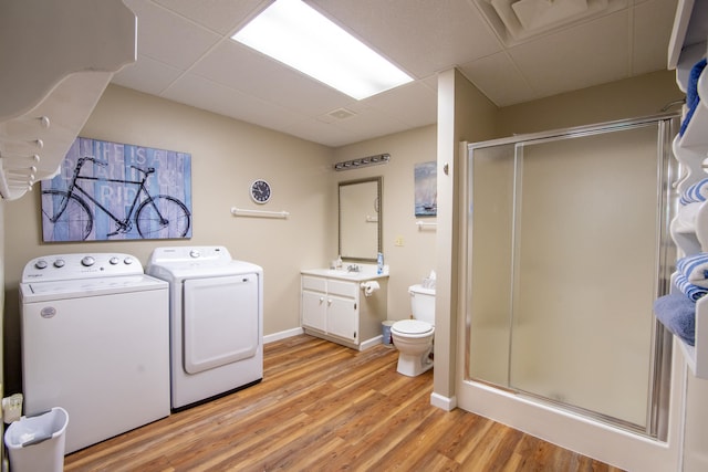 washroom with separate washer and dryer, sink, and light wood-type flooring