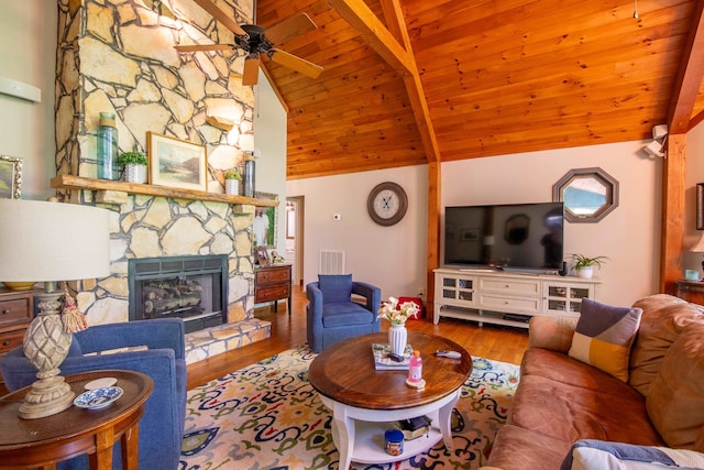 living room with beamed ceiling, ceiling fan, a fireplace, wood ceiling, and wood-type flooring