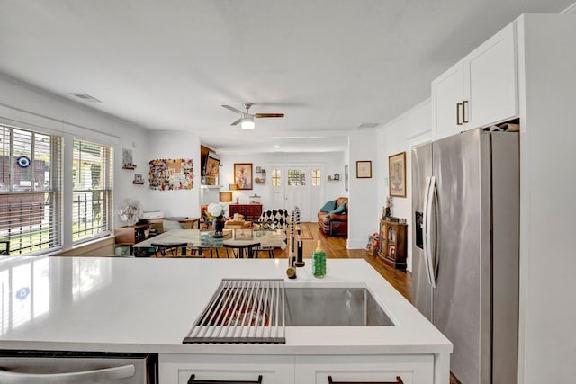 kitchen with ceiling fan, sink, white cabinetry, stainless steel appliances, and light hardwood / wood-style floors