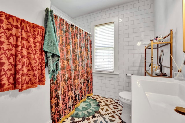 bathroom with tile walls, tile patterned flooring, toilet, and a shower with curtain